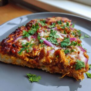 A slice of BBQ chicken pizza topped with red onion and cilantro on a gray plate.