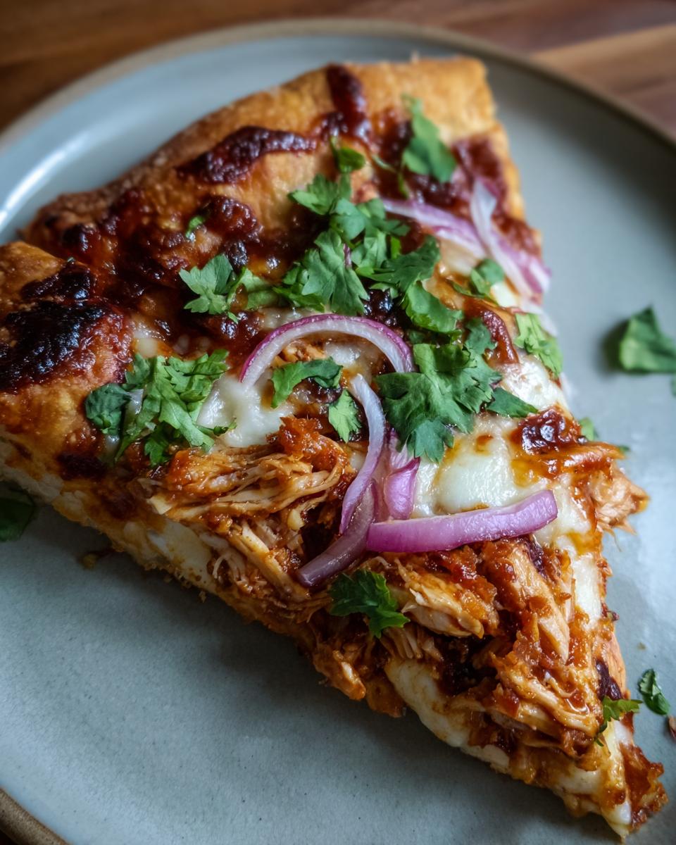 A slice of BBQ chicken pizza topped with red onion and cilantro on a gray plate. Delicious and easy to make!