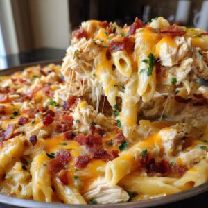 A close-up of chicken bacon ranch pasta bake with melted cheese, bacon bits, and parsley.