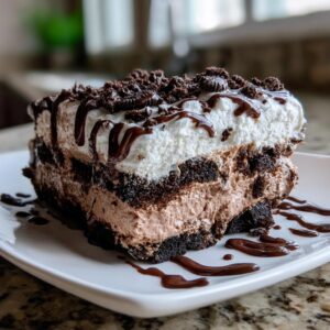A decadent slice of Chocolate Lasagna Dessert with layers of chocolate, cream, and whipped topping.