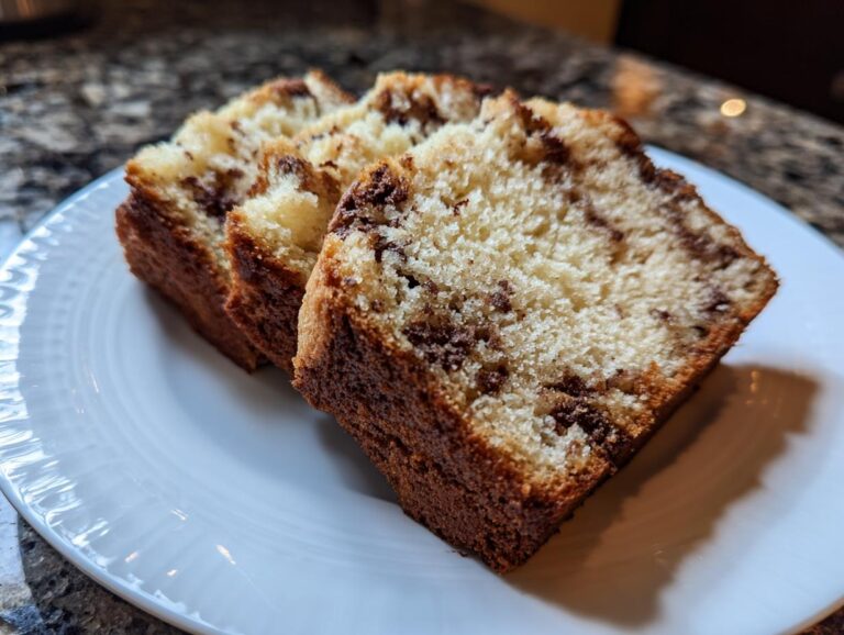 Three slices of freshly baked ice cream bread on a white plate, showcasing the bread's texture and color.
