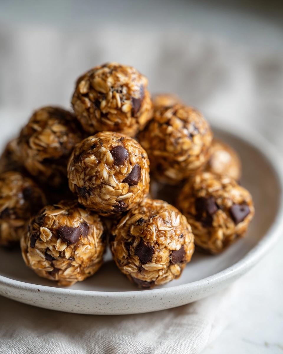 A stack of homemade Peanut butter oatmeal energy bites with chocolate chips on a white plate.