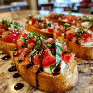 Close-up of tomato bruschetta with mozzarella, basil, and balsamic glaze on toasted bread.