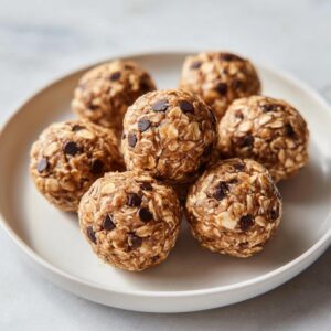 A plate of delicious No-Bake Oatmeal Energy Bites with visible oats and chocolate chips.