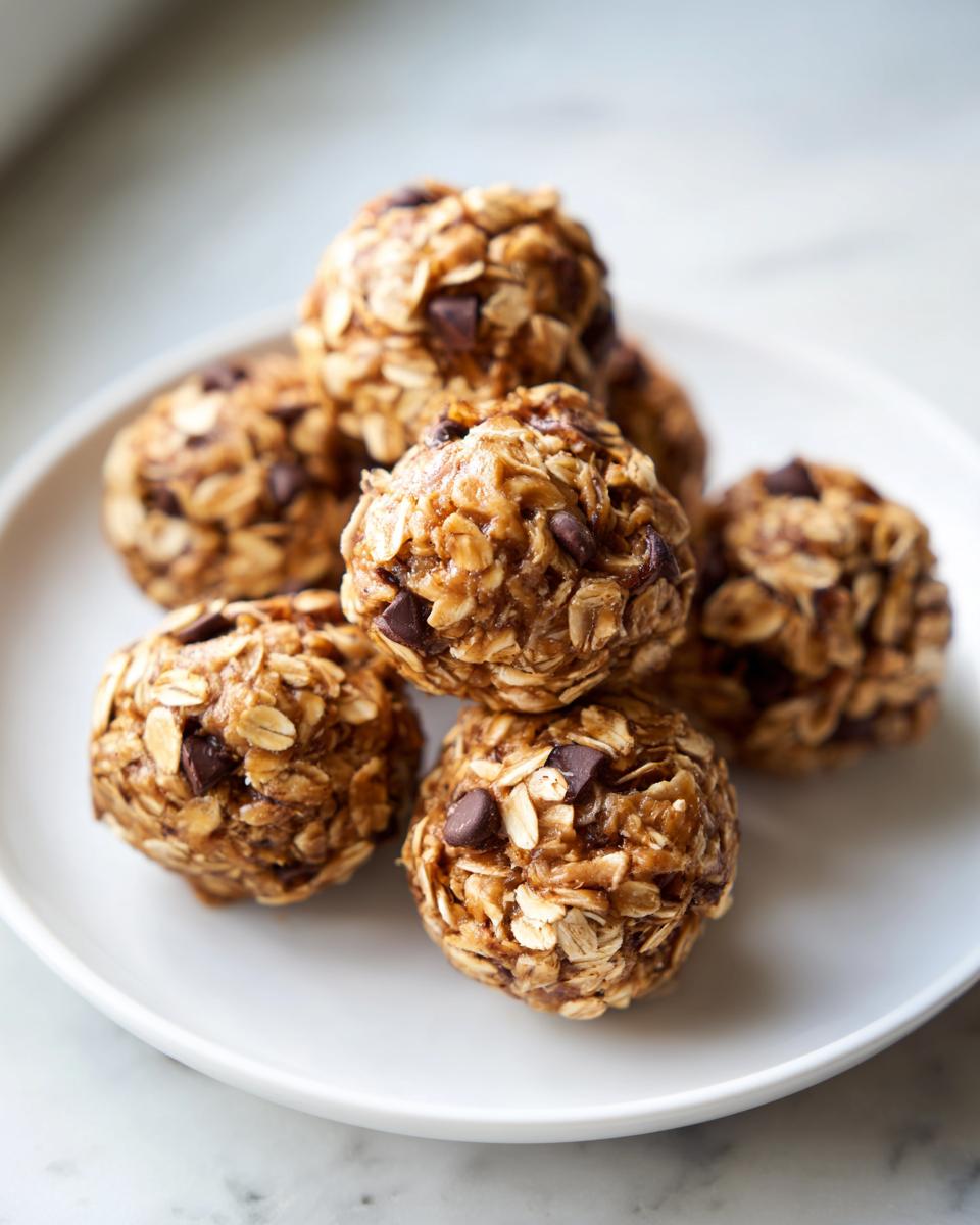A stack of delicious No-Bake Oatmeal Energy Bites with chocolate chips on a white plate.