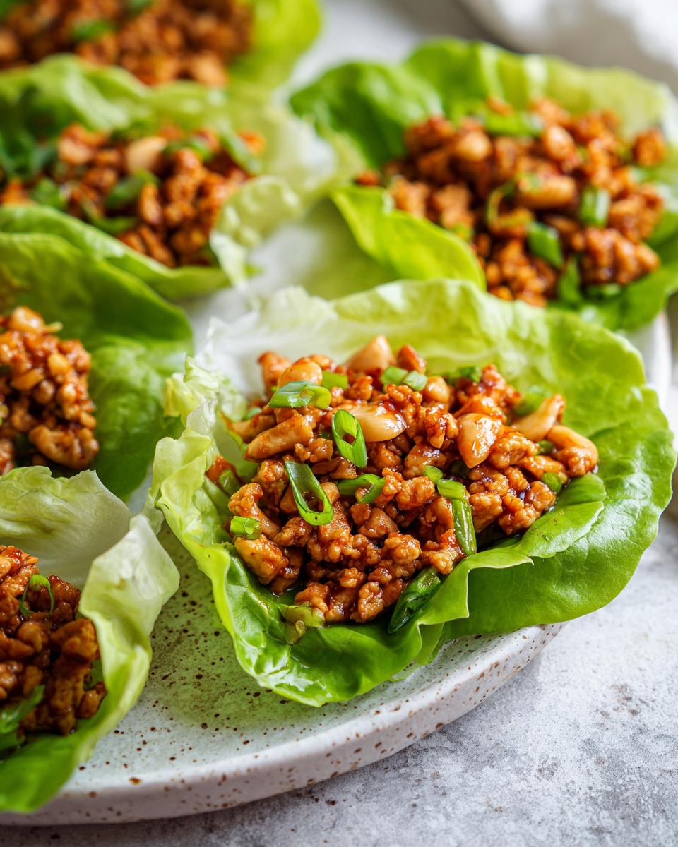 Close-up of delicious Chicken Lettuce Wraps Copycat PF Chang's, filled with seasoned ground chicken and topped with green onions.
