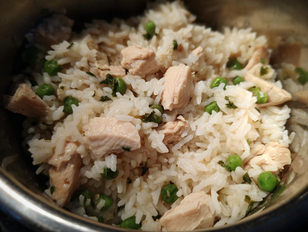 Close-up of Instant Pot Chicken and Rice with bright green peas and chopped parsley.
