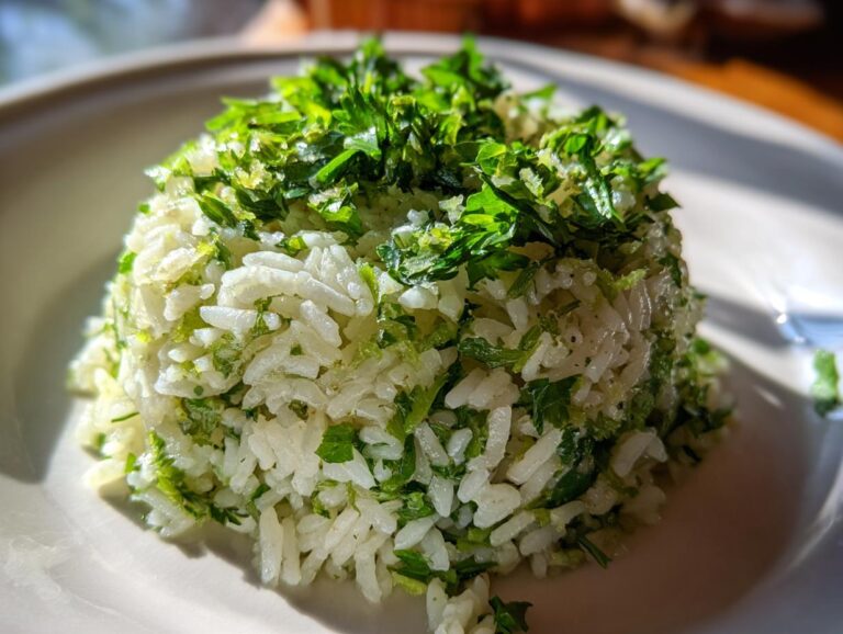 A perfectly molded serving of fluffy cilantro lime rice topped generously with fresh, bright green chopped cilantro.