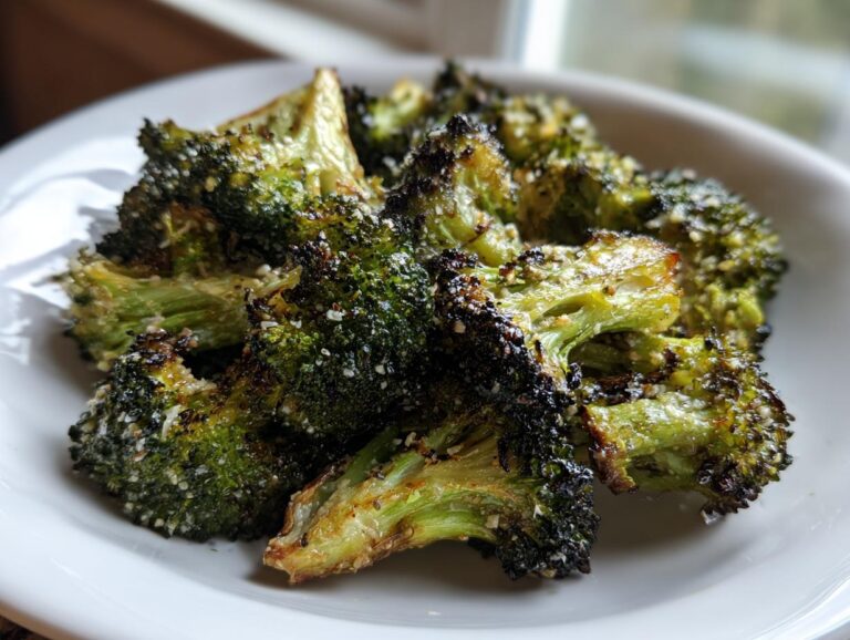 Close-up of perfectly roasted broccoli florets, showing crispy, dark edges and a light seasoning.