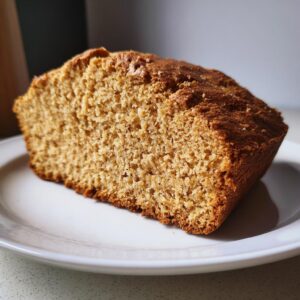 Close-up of a thick slice of golden brown soda bread showing its crumb texture on a white plate.