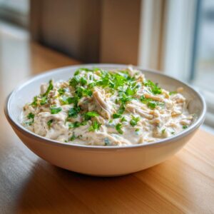A close-up of a creamy bowl of keto white chicken chili topped generously with fresh chopped parsley.