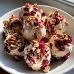 Close-up of creamy goat cheese balls rolled in dried cranberries and chopped pecans.