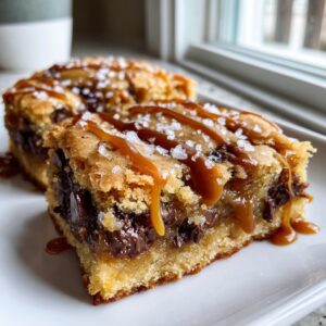 Two decadent salted caramel chocolate chip cookie bars drizzled with caramel and sea salt.